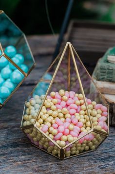 two glass containers filled with candies on top of a wooden table next to books