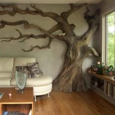 a living room with white furniture and a tree mural on the wall