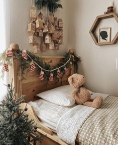 a teddy bear sitting on top of a bed next to a christmas tree and decorations