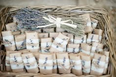 a basket filled with lots of wrapped gift bags next to a bundle of twine