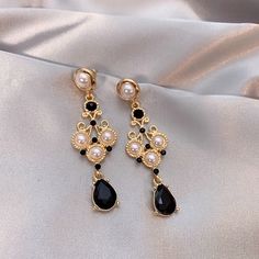 Beautiful vintage style black onyx and pearl lace dangle earrings. Delicate fan shape gold lace with pearls embedded, teardrop black gemstone dangle. Dark Gothic accent yet looks elegant and glamorous. Handmade dainty and sturdy earrings, gorgeous ear statement jewelry for parties and occasions and weddings. 💎 Features: ♥ Finish: 14K Gold plated, 925 sterling silver post ♥ Main Stone: black onyx zircon ♥ Side Stone: baroque pearl ♥ Push back closure ♥ Approximate Measurements: - Length: 2.7" - Black Earrings Outfit, Elegant Black Teardrop Pearl Earrings, Victorian Black Earrings For Party, Black Pearl Drop Party Jewelry, Black Pearl Drop Jewelry For Party, Elegant Black Beaded Chandelier Earrings, Vintage Black Earrings For Wedding, Black Pearl Earrings For Formal Occasions, Black Pearl Drop Earrings For Evening