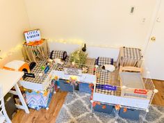 a living room filled with lots of furniture next to a white table and chair on top of a wooden floor