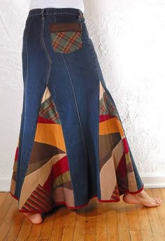 a woman is wearing a long skirt with a plaid design on it