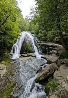 a small waterfall in the middle of a forest