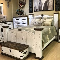 a bed room with a neatly made bed and dressers