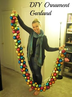 a woman is holding up an ornament made out of balls and beads in the shape of a heart