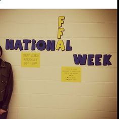 a woman standing in front of a wall with writing on it and the words national week written on it