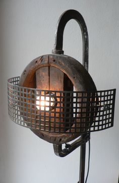 an old fashioned lamp with a caged light bulb on it's side, hanging from the wall