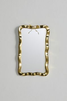 a gold framed mirror hanging on the wall