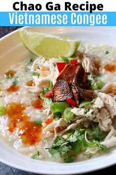 a white bowl filled with chicken and rice next to a lime wedge on the side