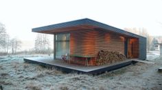 a small cabin in the middle of a field with frosty grass and trees around it