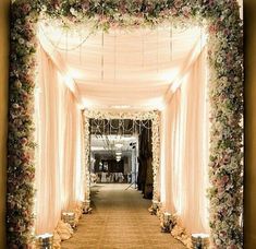 an archway decorated with flowers and candles