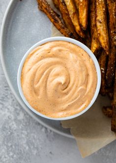 a white plate topped with french fries and dipping sauce