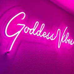 a neon sign that says goddess records on the side of a wall in a room