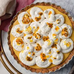 a pie with meringue, whipped cream and orange zest toppings on top