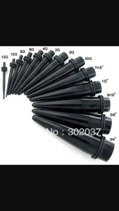 a bunch of black plastic umbrellas sitting on top of a white table next to a ruler