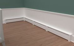 empty room with wooden flooring and green painted wall behind the bench area in the corner