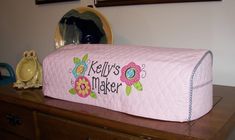 a pink quilted pillow sitting on top of a wooden dresser next to a mirror