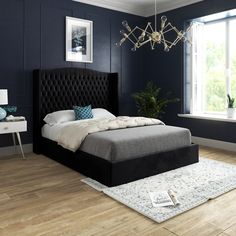 a bedroom with dark blue walls and wooden floors