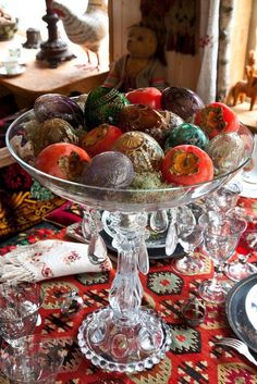 a glass bowl filled with lots of different types of fruit on top of a table