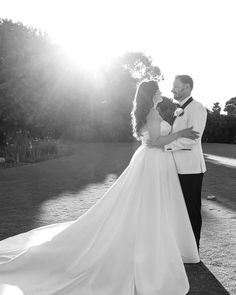 a bride and groom are standing in the sun on their wedding day, posing for a photo