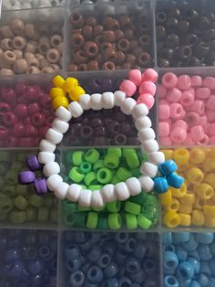 many different colored beads are in a plastic container with the word hello kitty on it