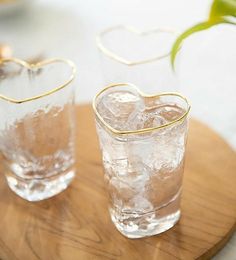 two glasses with ice in them on a wooden tray