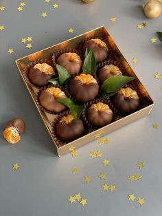 a box filled with chocolates sitting on top of a table next to gold stars