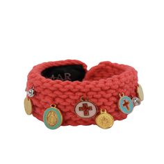 a red knitted bracelet with charms on it