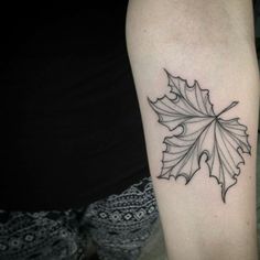 a black and white photo of a leaf tattoo