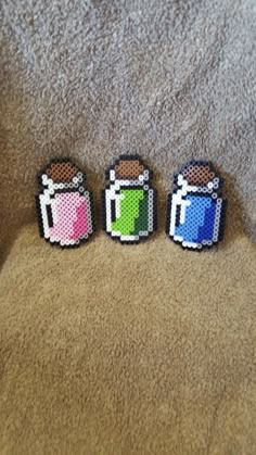 three pieces of pixel art sitting on top of a carpet