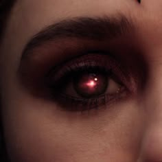 a woman's eye with red light coming out of it