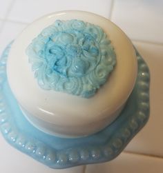 a blue and white cake sitting on top of a blue plate next to a tiled floor