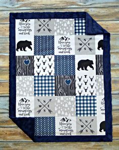 a blue and white quilted blanket with black bears, arrows, and words on it