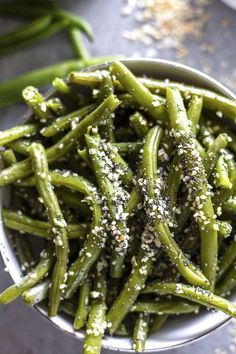 a bowl filled with green beans covered in seasoning