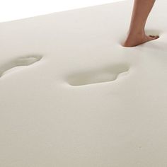 a person standing on top of a white mattress