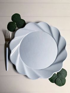 a white plate with green leaves and a fork