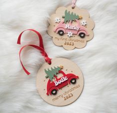 two personalized christmas ornament hanging from a red ribbon