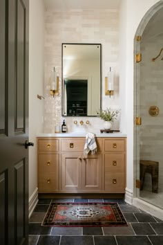 a bathroom with a sink, mirror and rug