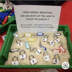 a green tray filled with sand and lots of magnets on top of it next to a sign that says hello number detectives can you work out the code to unlock this padlock?