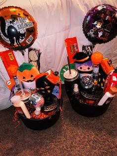 two buckets filled with halloween decorations and balloons