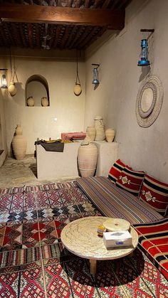 a living room filled with lots of different types of rugs and vases on the wall