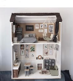 a doll house with furniture and pictures on the walls