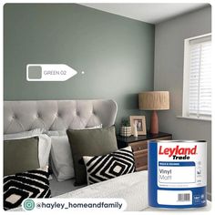 a bedroom with gray walls and white bedding has a paint can next to it