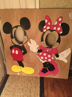 two cardboard cut outs of mickey and minnie mouses on the floor in front of a door