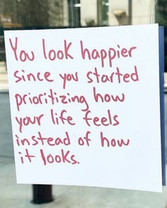 a sign posted on the side of a building that says you look happier since you started praizing how your life feels instead of how it looks