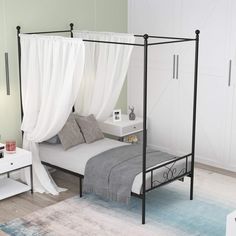 a bedroom with a canopy bed and white curtains