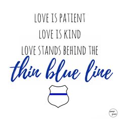 a blue line sign that says love is patient love is kind love stands behind the thin blue line