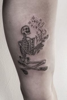 a skeleton sitting on the ground with flowers in it's hand and holding a flower