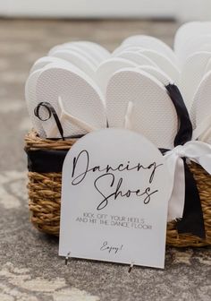 a basket filled with white flip flops sitting on top of a floor